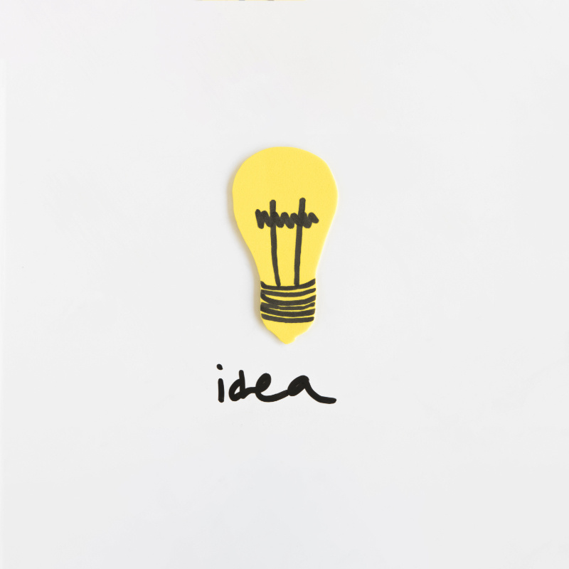 high-angle-view-light-bulb-with-idea-text-white-backdrop